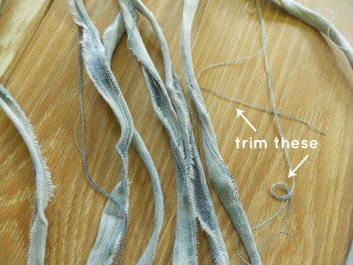 image of strips of denim yarn with fibers that need to be trimmed