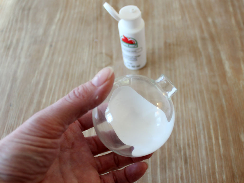 Pour white paint into glass ornament