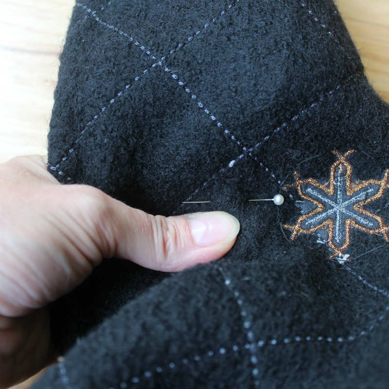 Place a pin on the seam line of the sweater sleeve