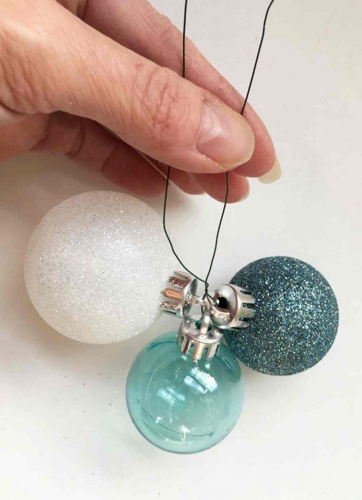 three ball ornaments tied together with floral wire