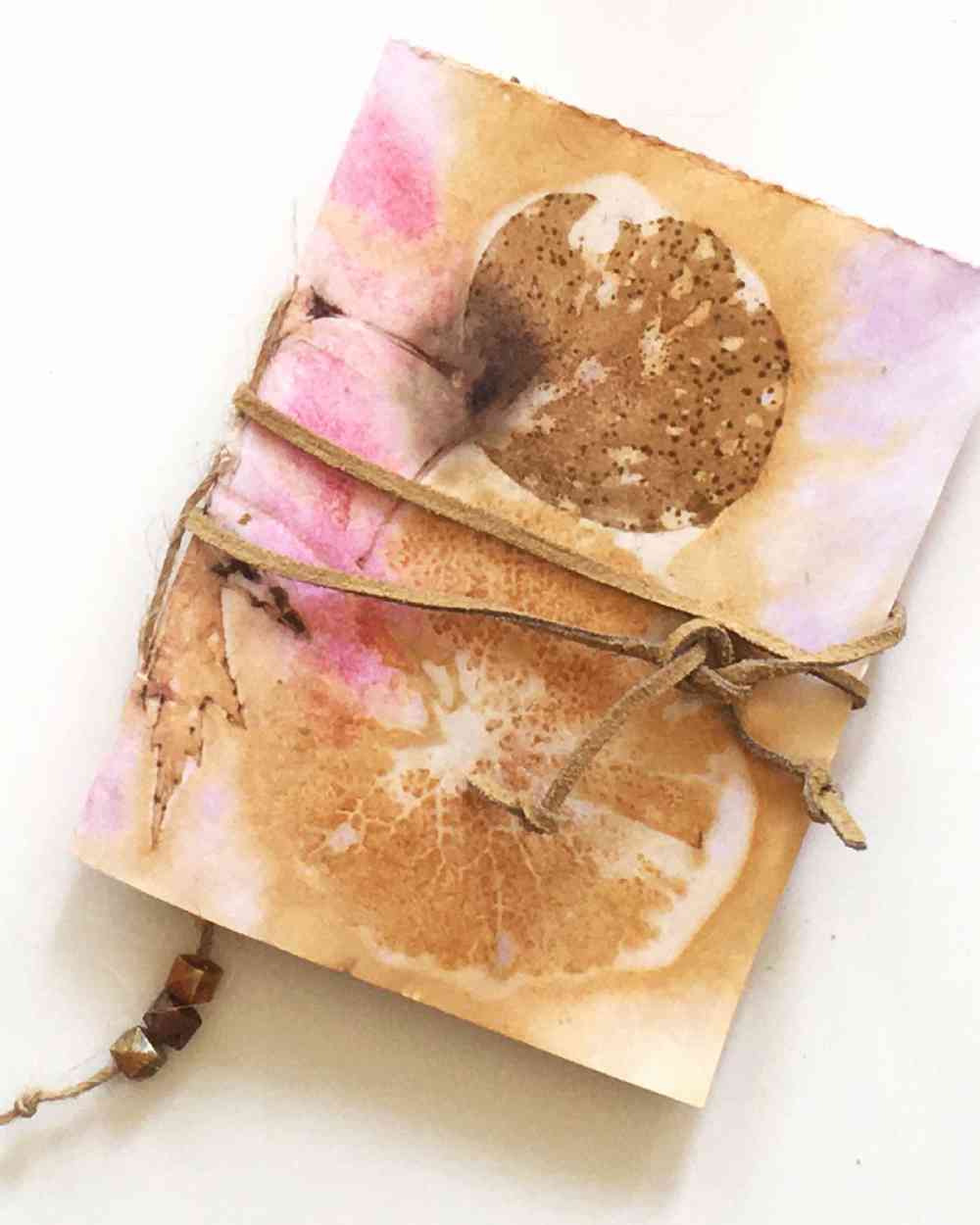 A journal made with leaf printed paper and leather strap