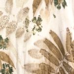 brown and green printed leaves and flowers on off white fabric