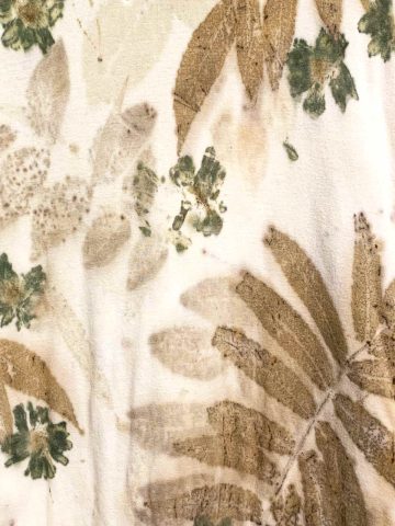brown and green printed leaves and flowers on off white fabric